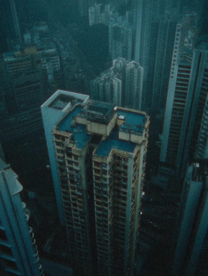 Grainy aerial view of high-rise building in Hong Kong under overcast lighting, showcasing cinematic AI color matching and film emulation in Color.io app